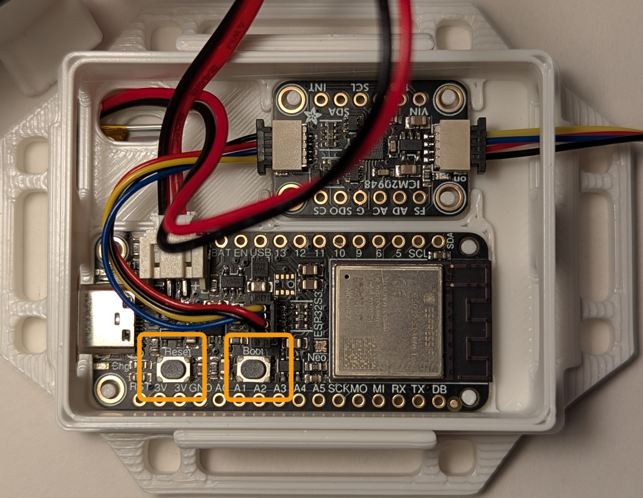Close-up of the ICM-20948 IMU breakout and ESP32-S3 Feather with the reset and boot buttons highlighted